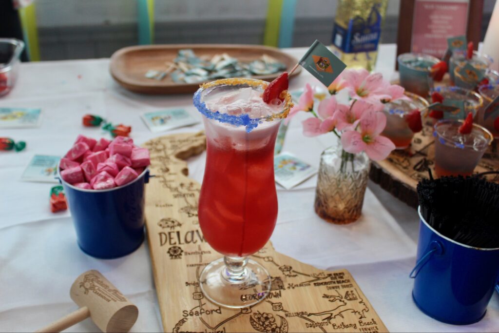 a table topped with a glass filled with a red drink
