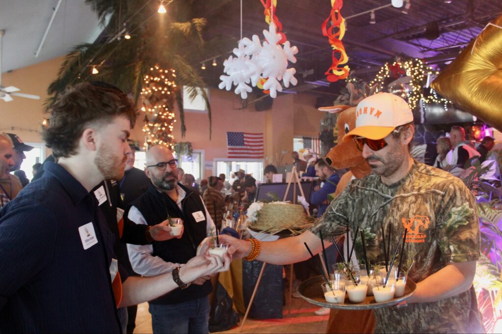 a group of men standing around a cake
