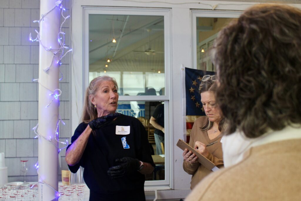 a woman standing in front of a mirror talking to another woman