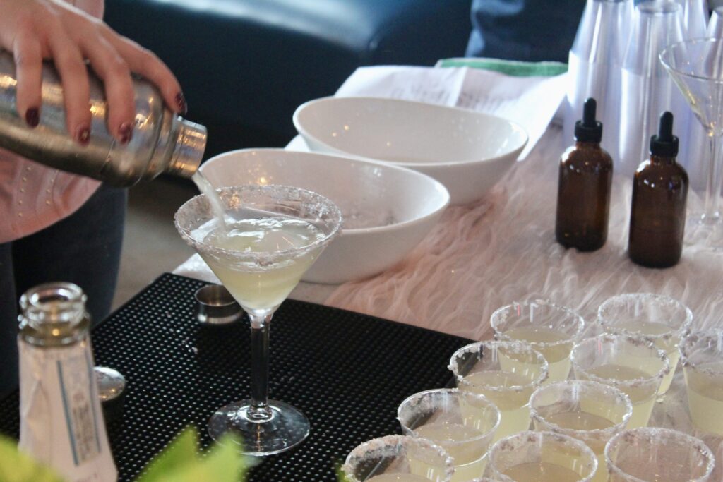 a person pouring a drink into a glass