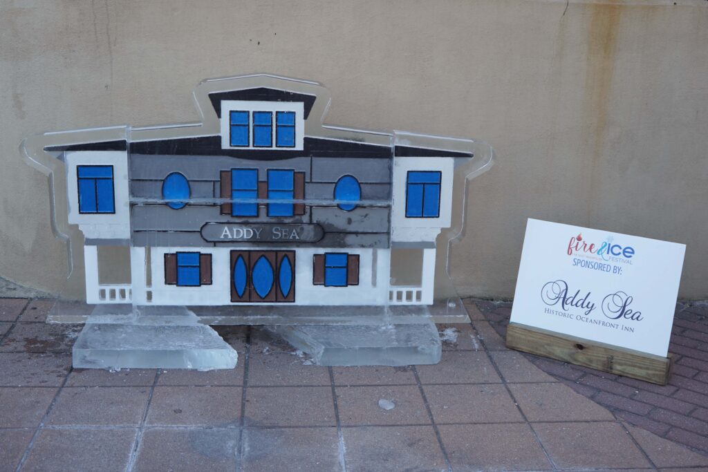 a model of a house with a sign in front of it