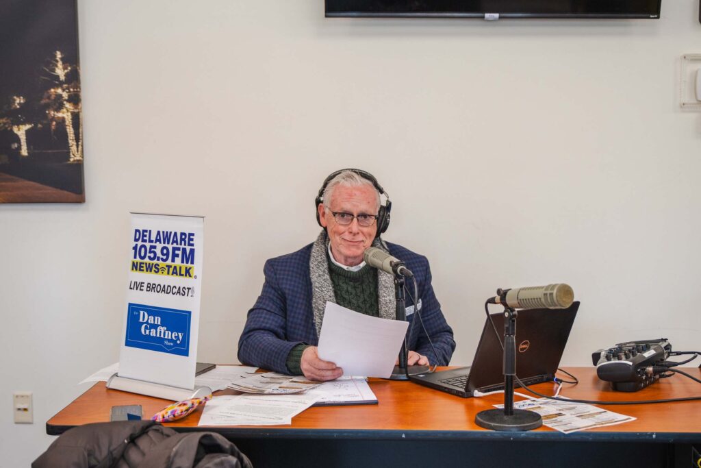 a man sitting at a desk in front of a laptop computer