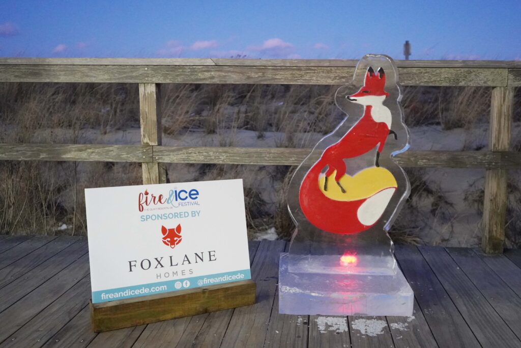 a wooden deck with a sign and a statue of a fox