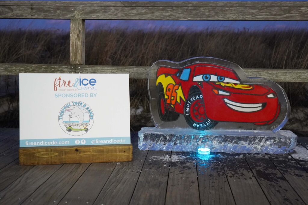 an ice sculpture of a red car on a wooden deck
