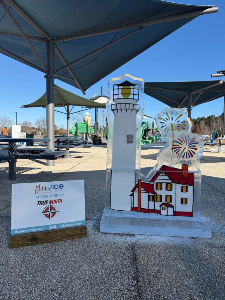 a white and red lighthouse next to a sign