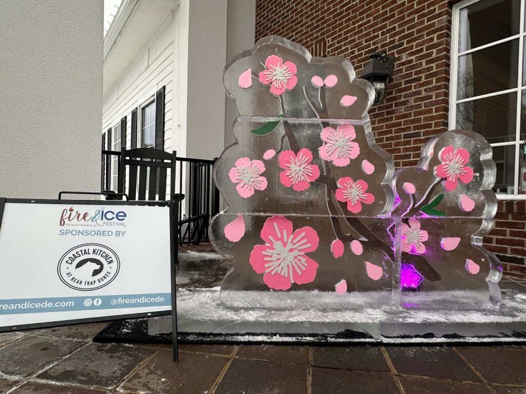 a large ice sculpture with pink flowers on it