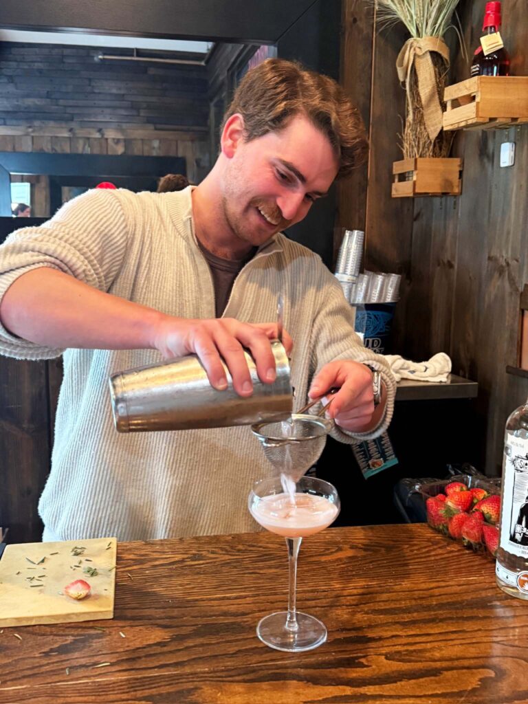 a man pouring a drink into a glass