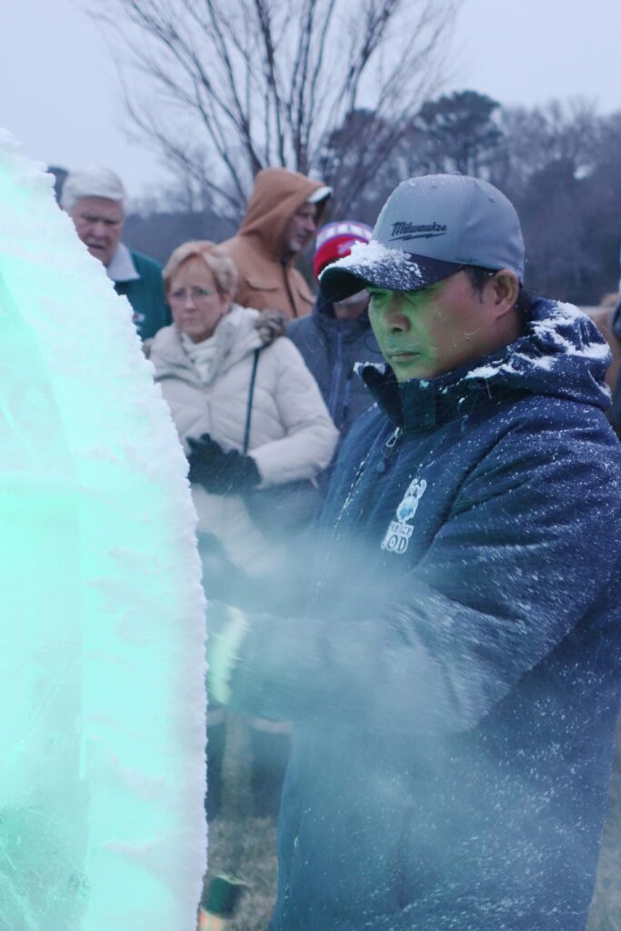 a group of people standing around an ice sculpture