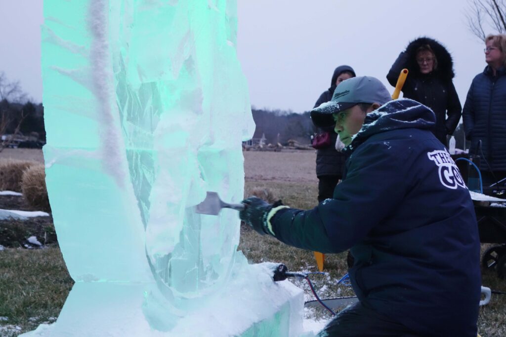 a group of people standing around an ice sculpture