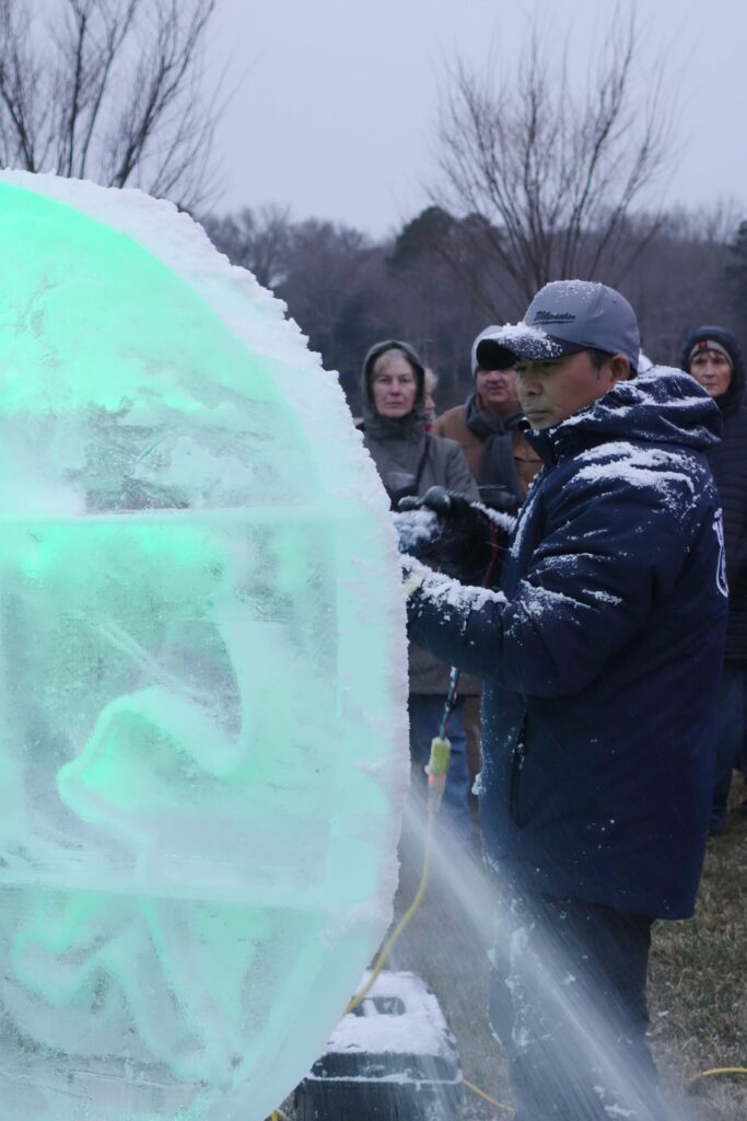 a group of people standing around an ice sculpture