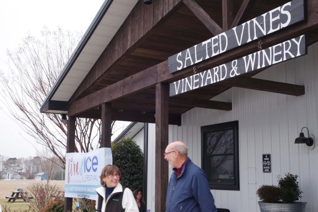 a man and a woman walking in front of a winery