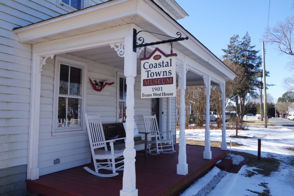 a white house with rocking chairs on the front porch