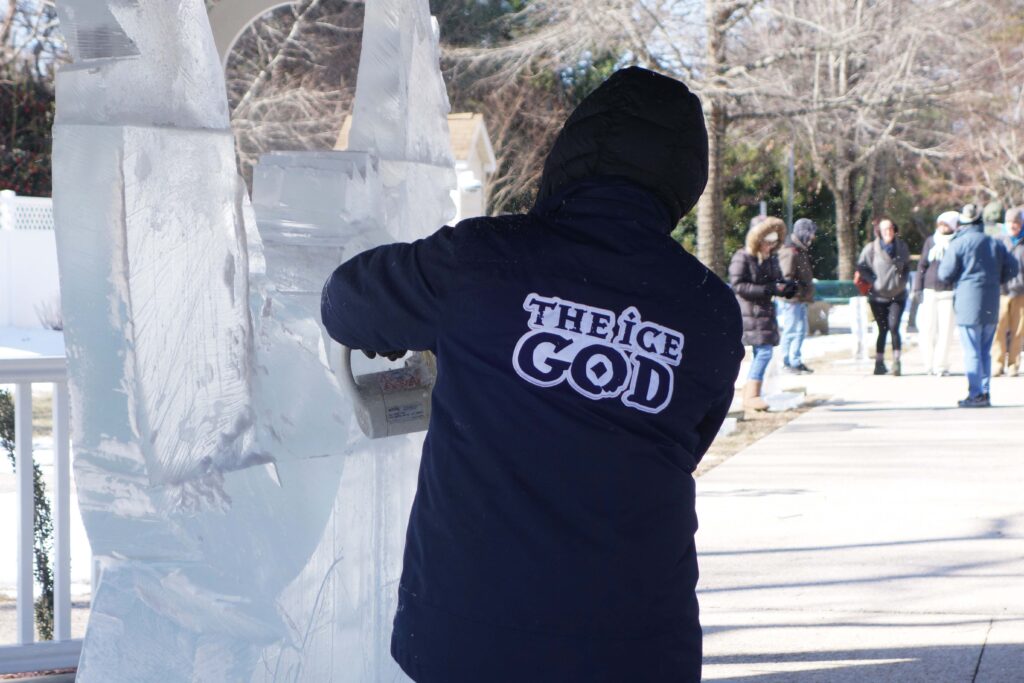 a person standing next to a snow sculpture