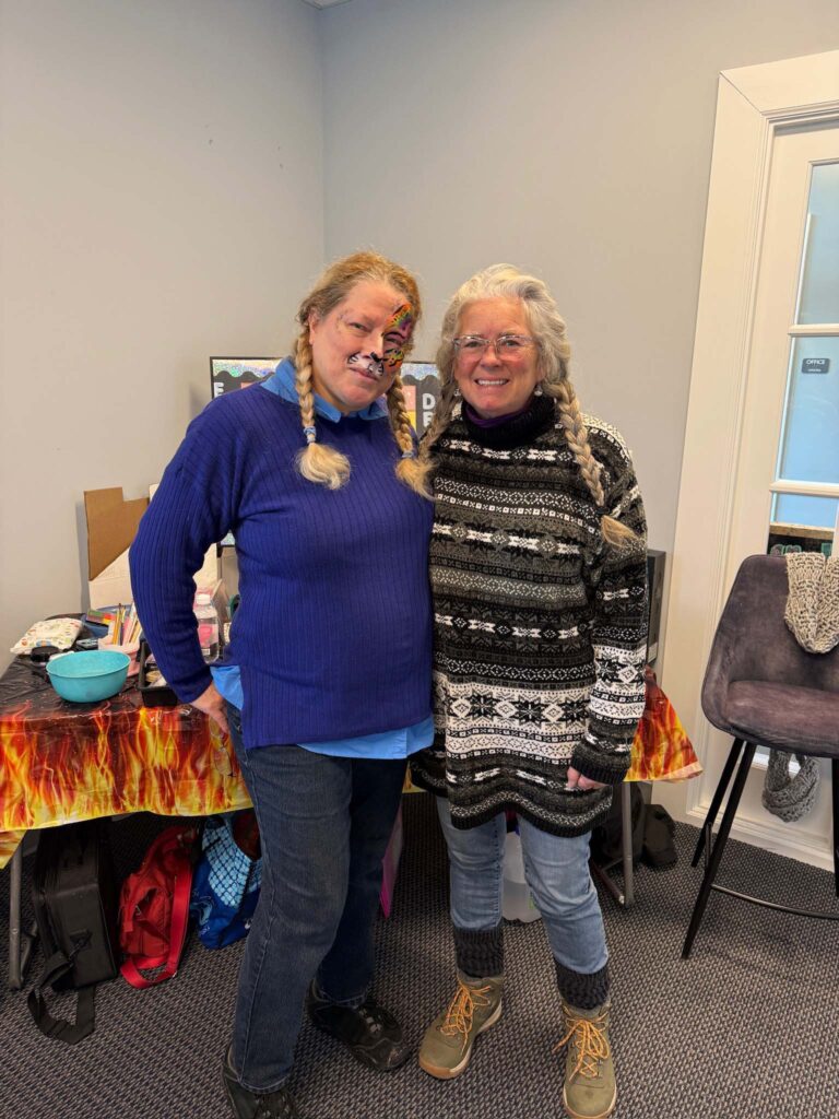 two women standing next to each other in a room