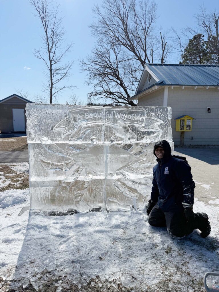 a man kneeling down in front of an ice sculpture