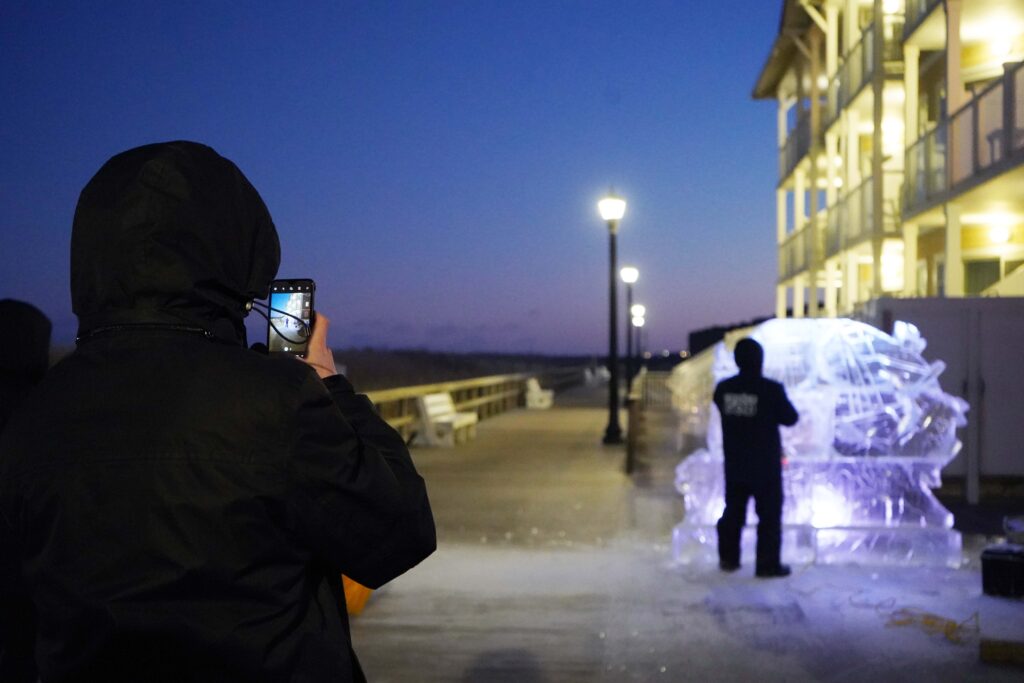 a person taking a picture of a building at night
