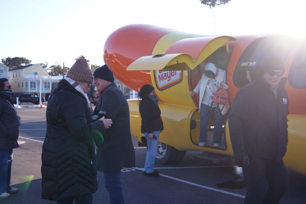 a group of people standing around a hot dog truck