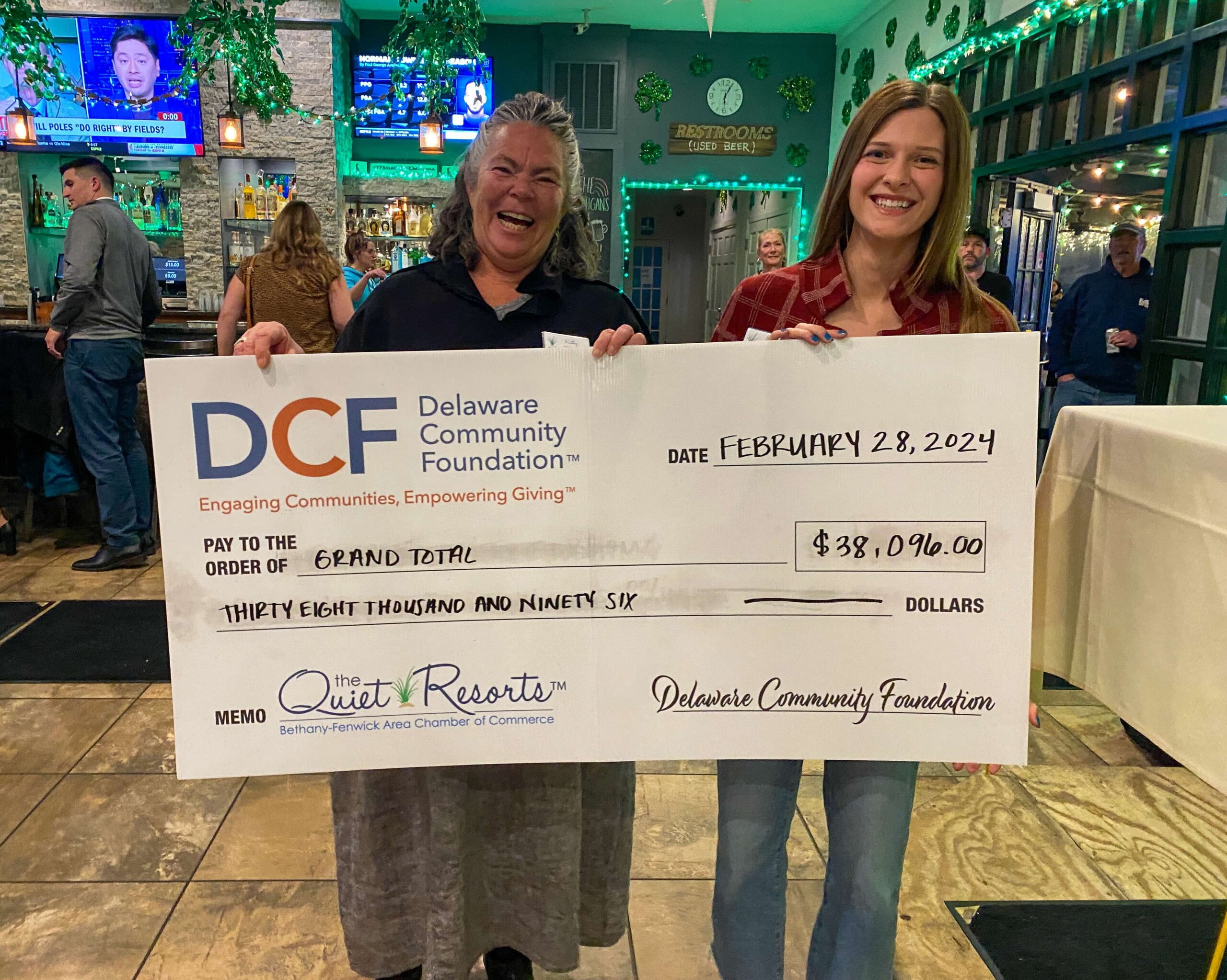 a man and a woman holding a large check