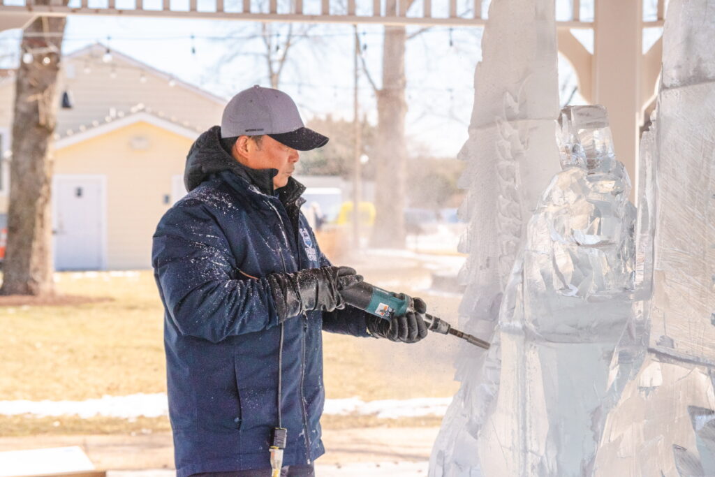 a man standing next to a snow sculpture