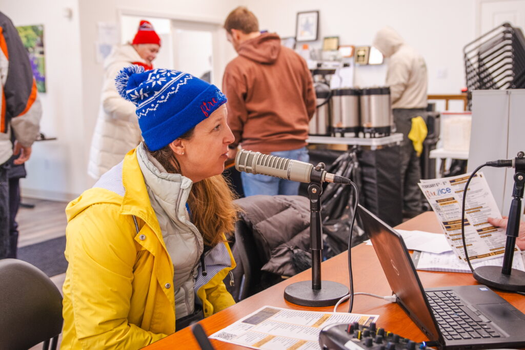 a woman sitting at a desk in front of a microphone