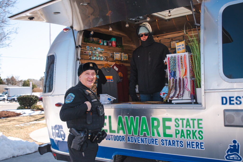 a police officer standing in front of a food truck
