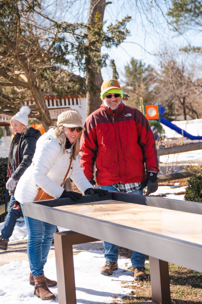 a group of people standing around a wooden bench