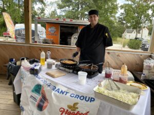 a man standing next to a table with food on it