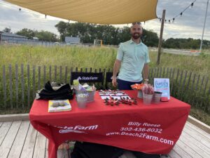 a man standing next to a red table covered in food