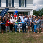 a group of people standing in front of a house