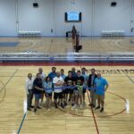 a group of people standing on top of a basketball court