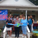 a group of people standing outside of a house