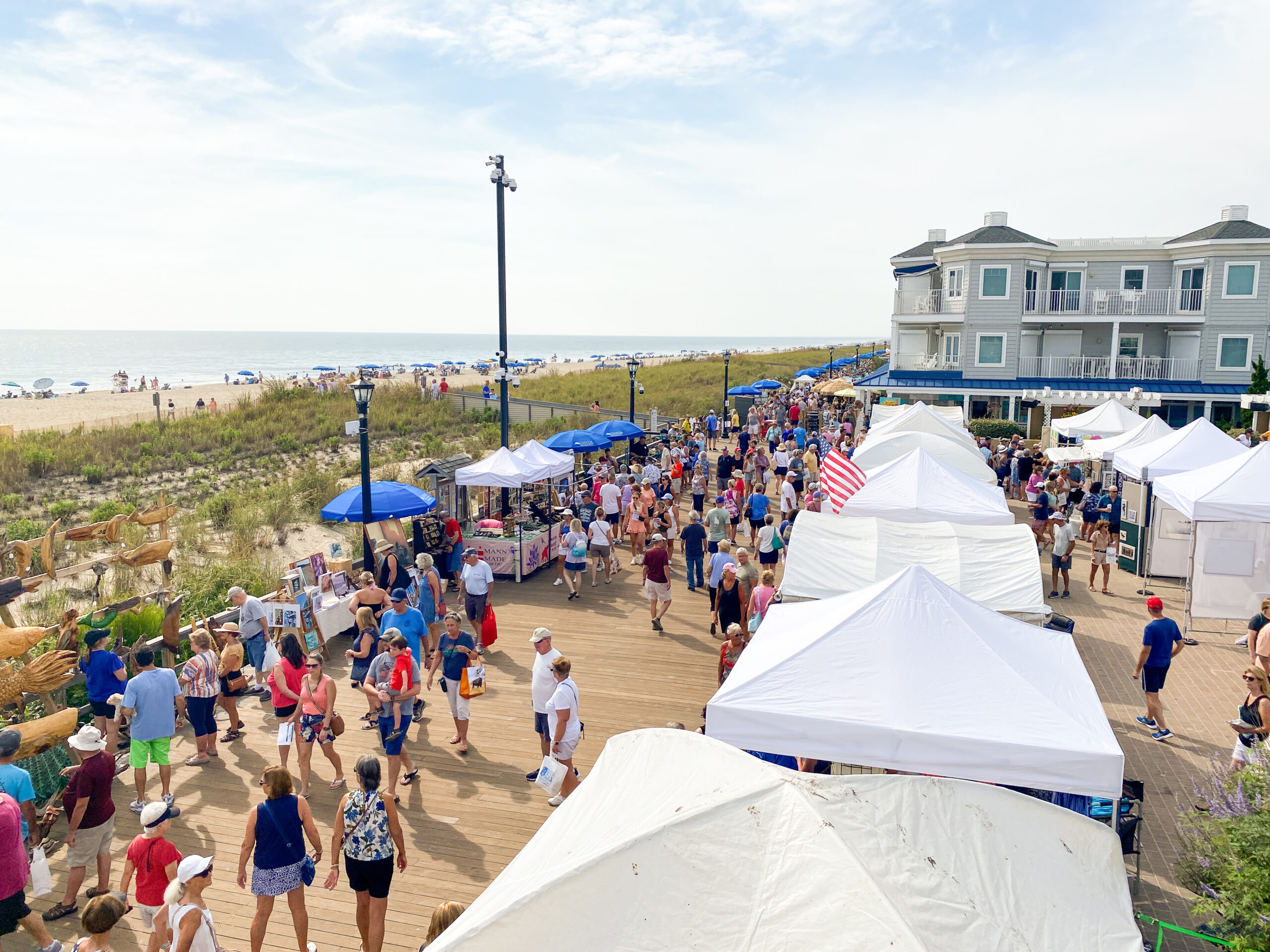 a crowd of people walking along a sandy beach