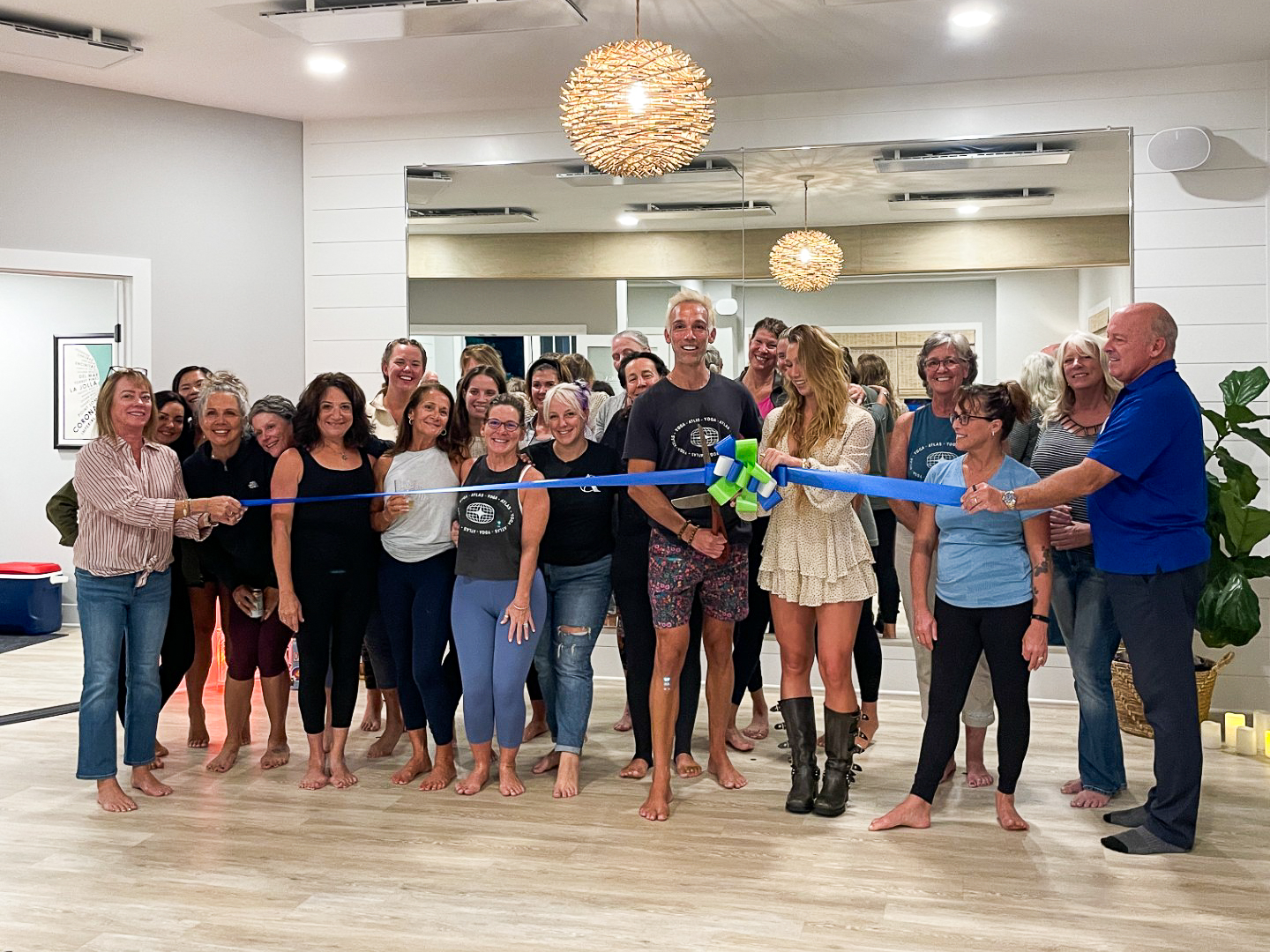 a group of people holding a ribbon in a room