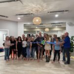 a group of people holding a ribbon in a room