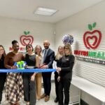 a group of people cutting a ribbon in a room