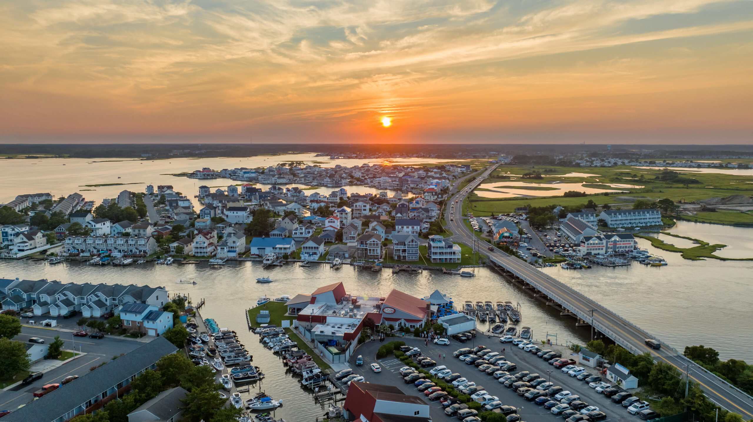 an aerial view of a marina with a sunset in the background