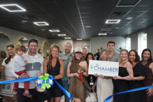a group of people holding a ribbon cutting a ribbon