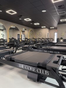 a gym with rows of treadmills and mirrors