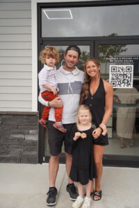 a man, woman and two children standing in front of a building