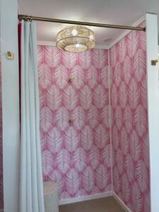 a bedroom with pink and white wallpaper and a bed