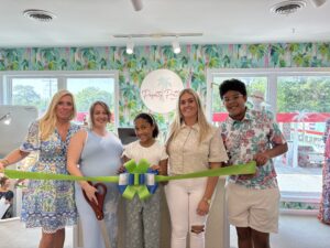 a group of people holding a ribbon in a room