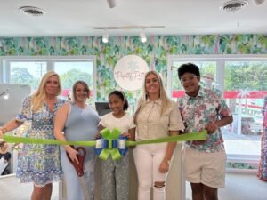 a group of people holding a ribbon in a room