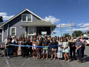 a group of people standing in front of a blue ribbon