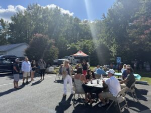 a group of people sitting around a table in a parking lot