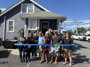a group of people standing in front of a blue ribbon