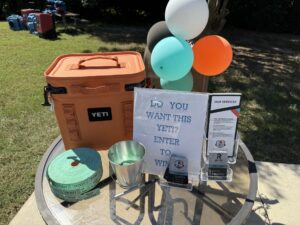 a table with balloons and a sign on it