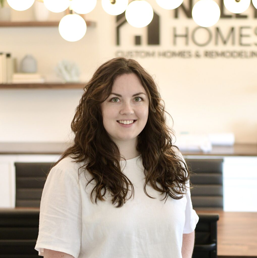 a woman standing in front of a wooden table