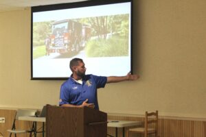 a man standing at a podium giving a presentation