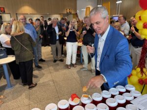 a man in a blue suit serving drinks to a group of people