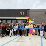 a group of people standing in front of a mcdonalds